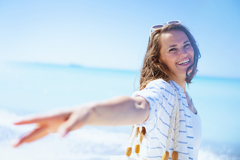 Smiling woman in front of the beach