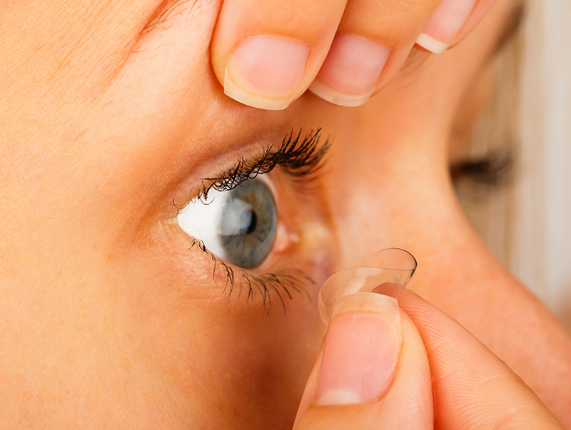 Woman removing contact lens